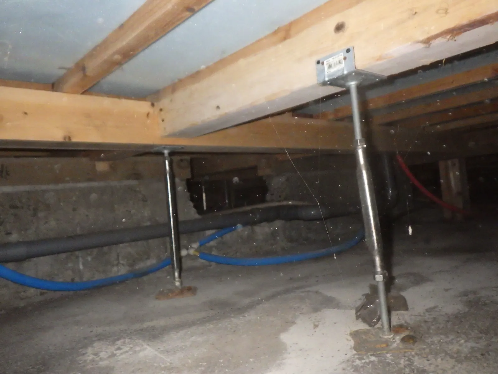 床下点検の写真。木の土台と鋼製束、配管の状態を確認
