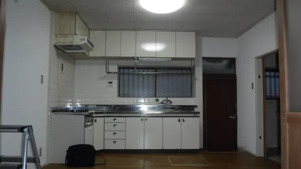 施工前のキッチン。壁に向かって流し台とコンロが並んでいる
