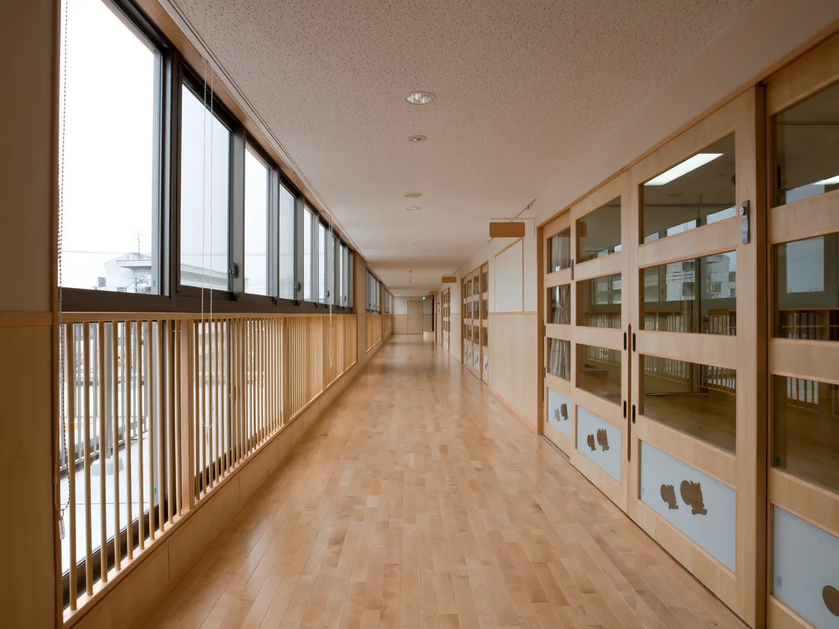 松島りすの森保育園の2階廊下。低い位置の窓と木の格子