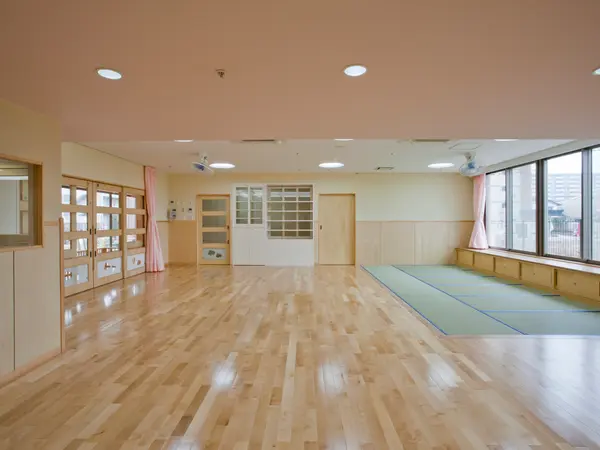 松島りすの森保育園の乳児室（0歳児）。木の床と畳のコーナー、大きな窓