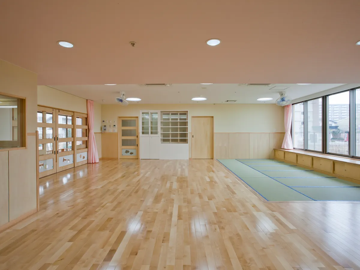 松島りすの森保育園の乳児室（0歳児）。木の床と畳のコーナー、大きな窓