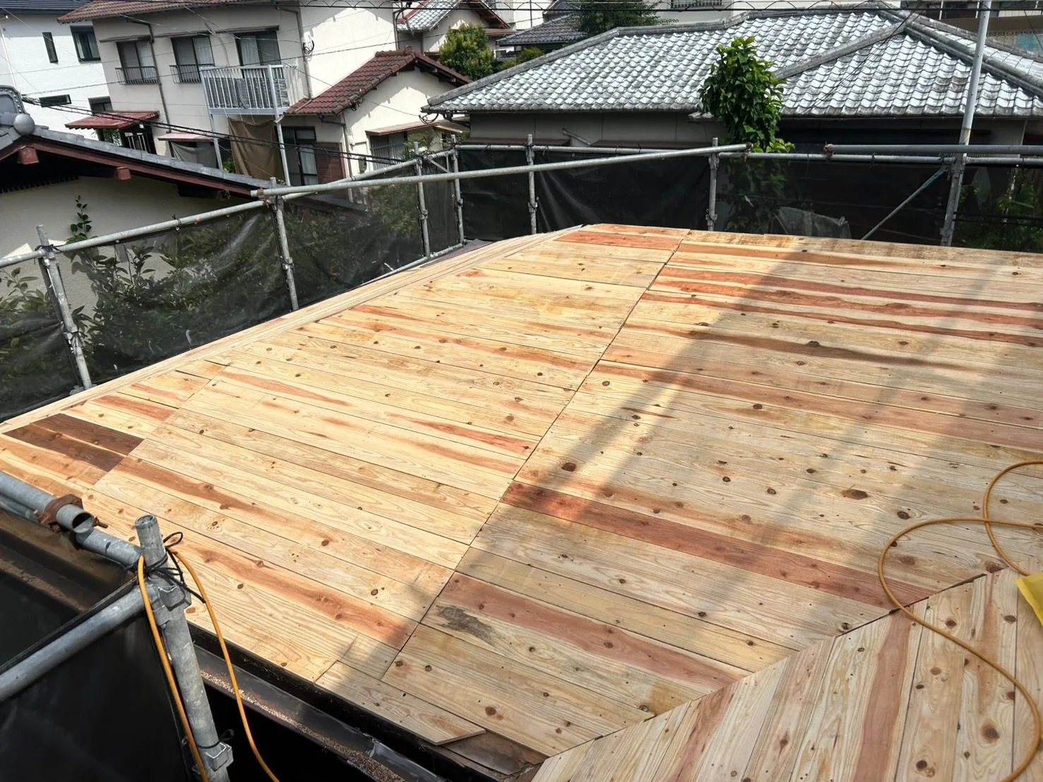 既存のセメント瓦を撤去し、野地板を重ね張りした屋根