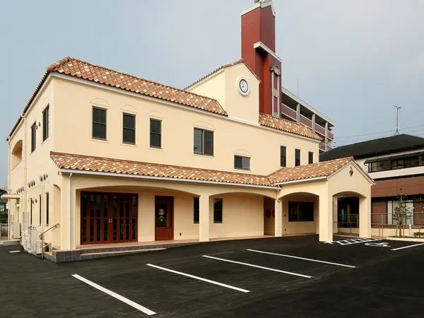 ふくしセンター多の津の外観。赤い瓦屋根と時計塔のあるクリーム色の建物